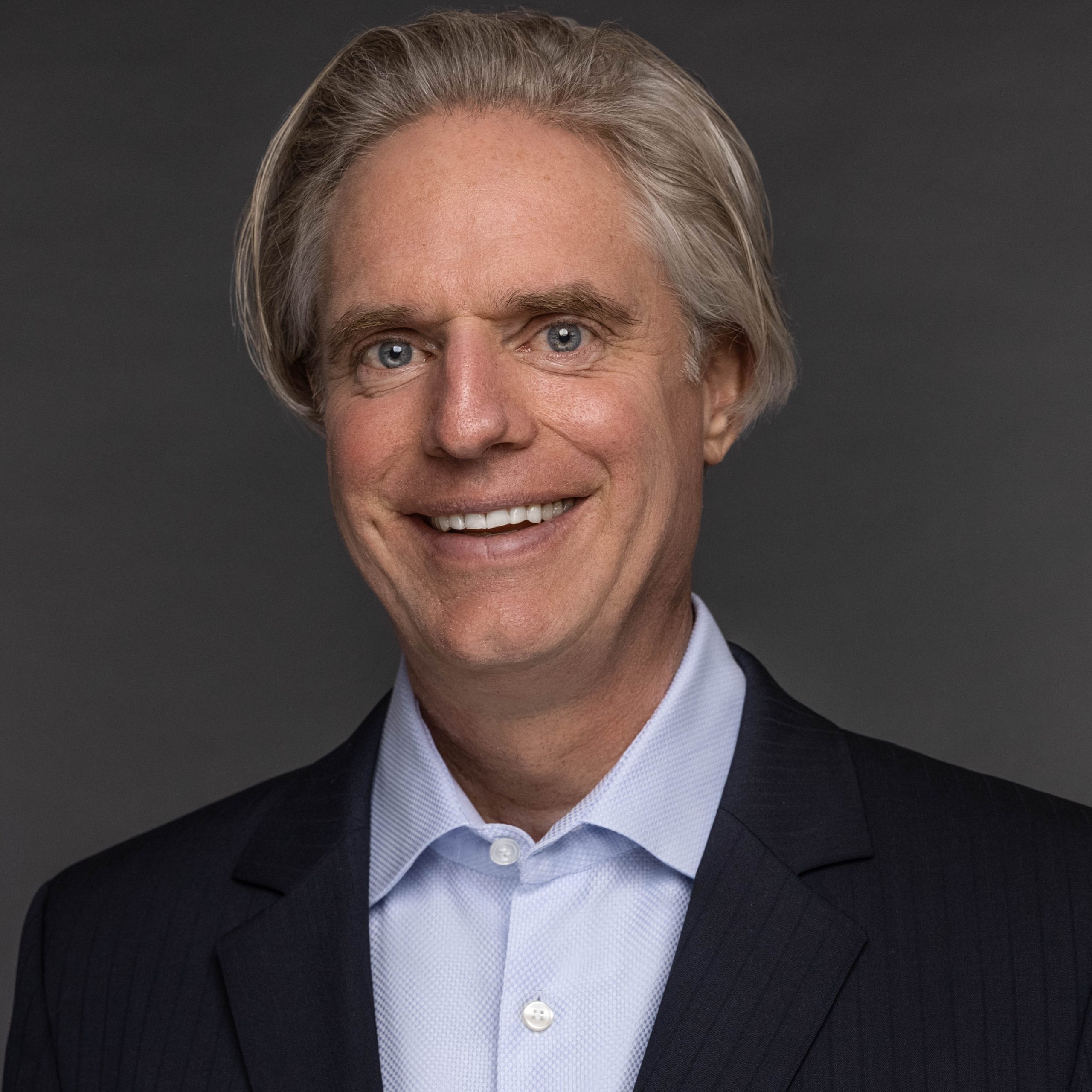 IMPACT Board Member Brian Sullivan, man in suit smiling at camera