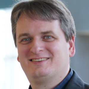 The IMPACT Center Board Member, Christian Vogler headshot. Man looking at camera smiling